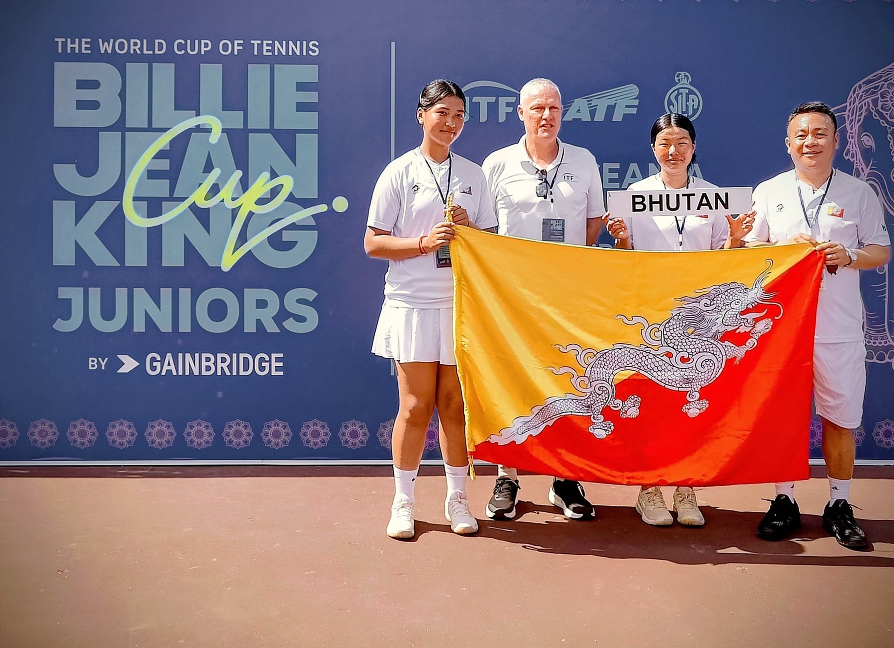 The Bhutan team holding the national flag at the Billie Jean King Cup Juniors