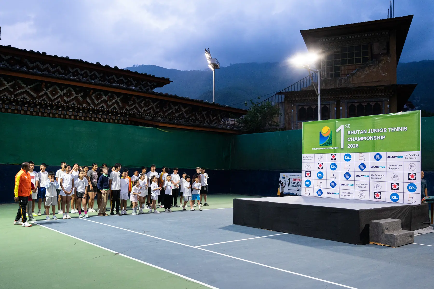 Players gathered on court under floodlights for the prize-giving at the Bhutan Junior Tennis Championship