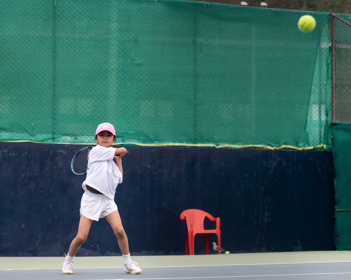A young player driving a two-handed backhand