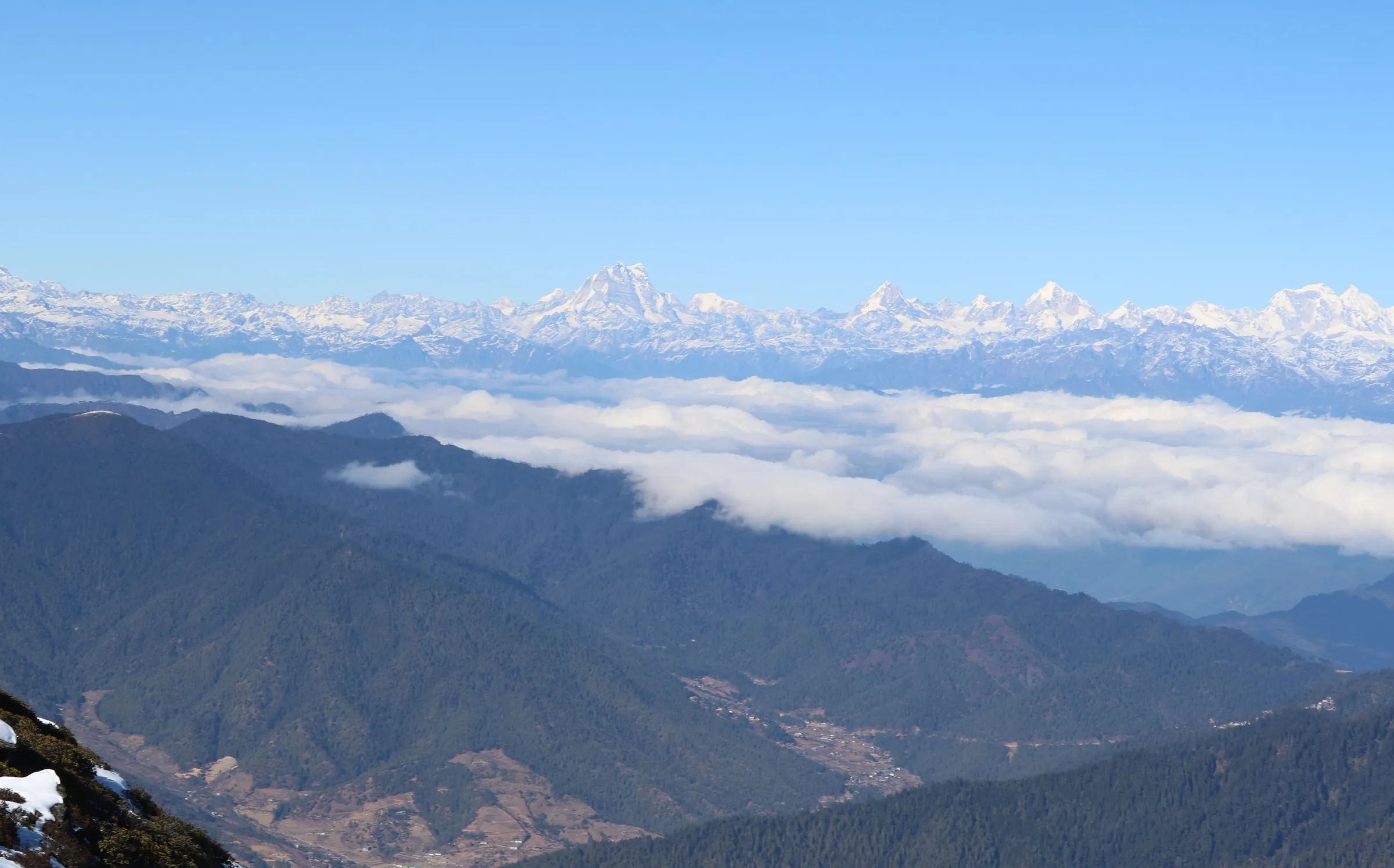 The Thimphu valley far below, a sea of cloud and the snow-capped eastern Himalaya beyond, seen from Talakha Peak